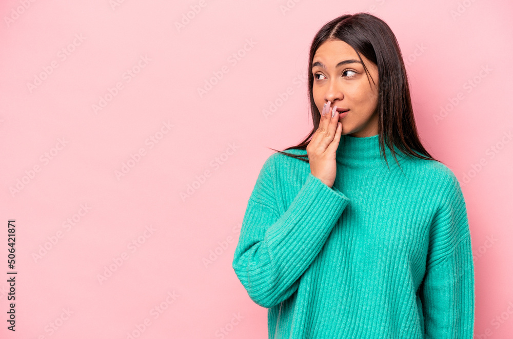 Young hispanic woman isolated on pink background is saying a secret hot braking news and looking aside Young hispanic woman isolated on pink background is saying a secret hot braking news and looking aside