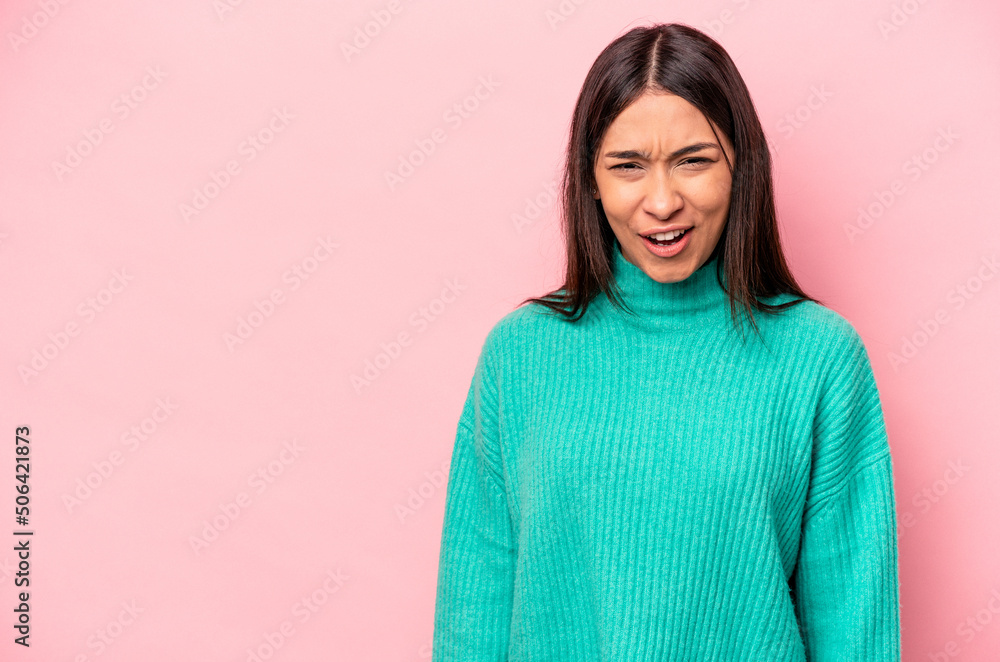 Fototapeta premium Young hispanic woman isolated on pink background shouting very angry, rage concept, frustrated.