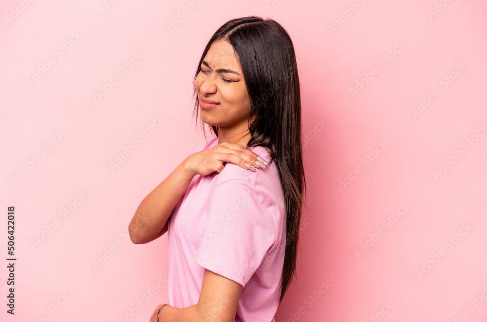 Young hispanic woman isolated on pink background having a shoulder pain. Young hispanic woman isolated on pink background having a shoulder pain.