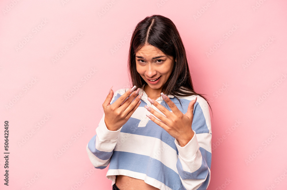 Young hispanic woman isolated on pink background pointing with finger at you as if inviting come closer. Young hispanic woman isolated on pink background pointing with finger at you as if inviting come closer.
