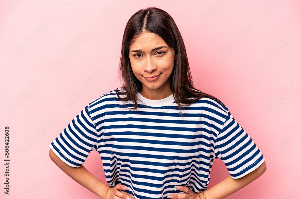 Fototapeta premium Young hispanic woman isolated on pink background sad, serious face, feeling miserable and displeased.