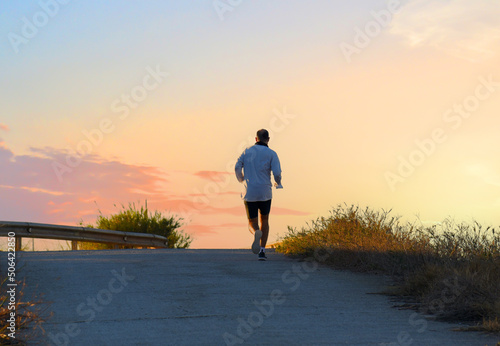 Runner on sunset. Run in sprint on footpath. Man sprinter on sunset. Male running for exercise. Athlete runner feet running on sunrise. Person during Jogging at outdoors. Men on marathon of running. © MaxSafaniuk