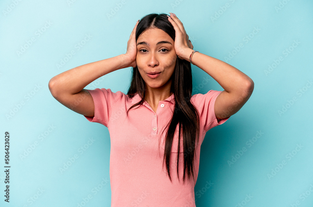 Young hispanic woman isolated on blue background being shocked, she has remembered important meeting. Young hispanic woman isolated on blue background being shocked, she has remembered important meeting.