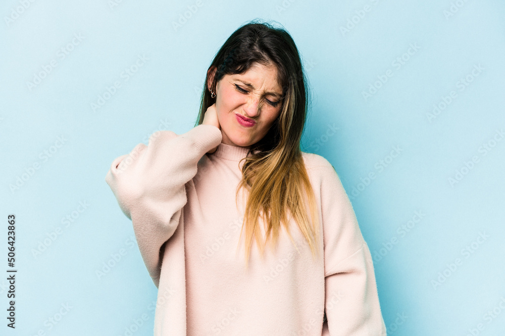 Young caucasian woman isolated on blue background having a neck pain due to stress, massaging and touching it with hand. Young caucasian woman isolated on blue background having a neck pain due to stress, massaging and touching it with hand.