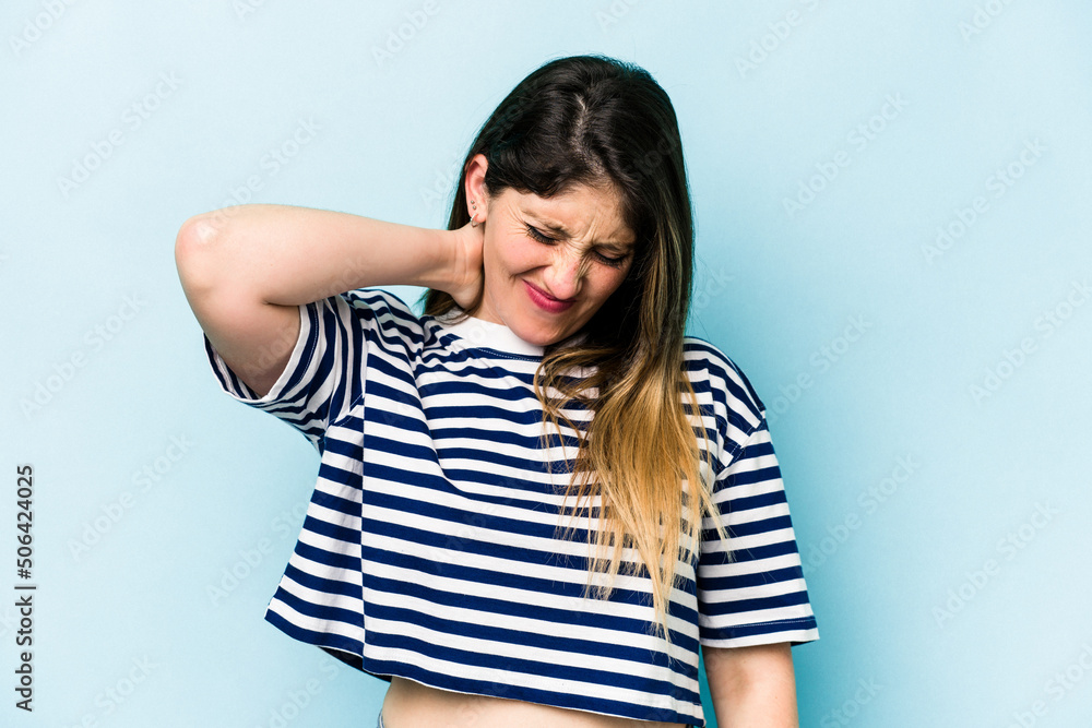 Young caucasian woman isolated on blue background having a neck pain due to stress, massaging and touching it with hand. Young caucasian woman isolated on blue background having a neck pain due to stress, massaging and touching it with hand.