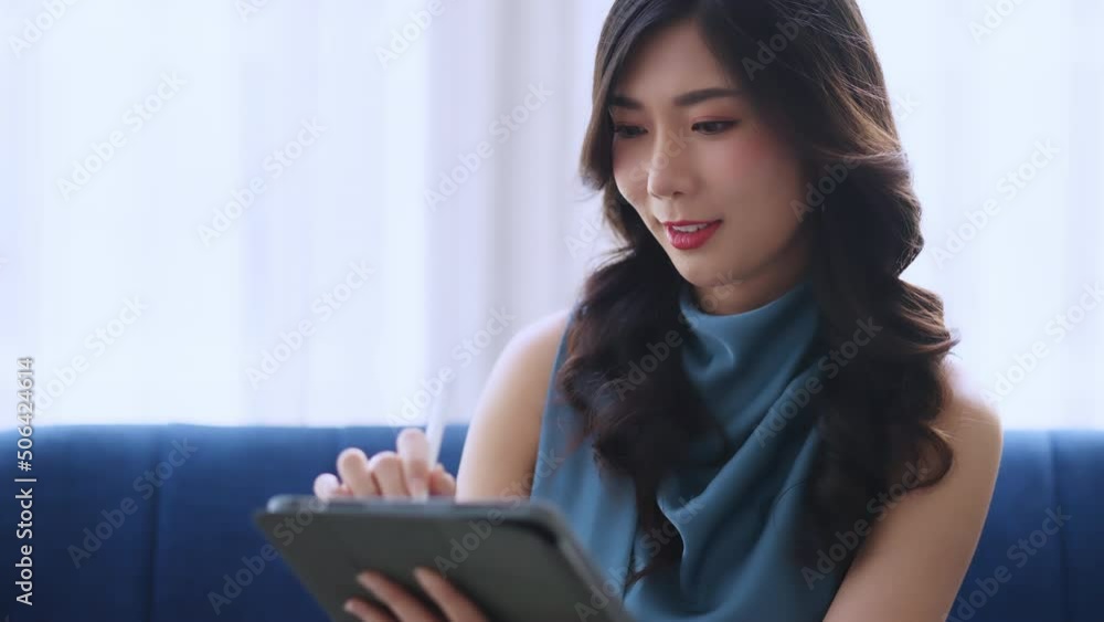 casual working at home relax casual using tablet device in living room,asian female adult hand typing search or texting via laptop sofa working from home with happiness peaceful smiling ideas concept casual working at home relax casual using tablet device in living room,asian female adult hand typing search or texting via laptop sofa working from home with happiness peaceful smiling ideas concept