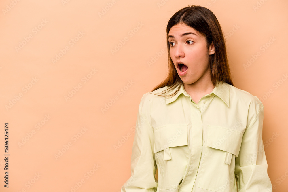 Young hispanic woman isolated on beige background being shocked because of something she has seen. Young hispanic woman isolated on beige background being shocked because of something she has seen.