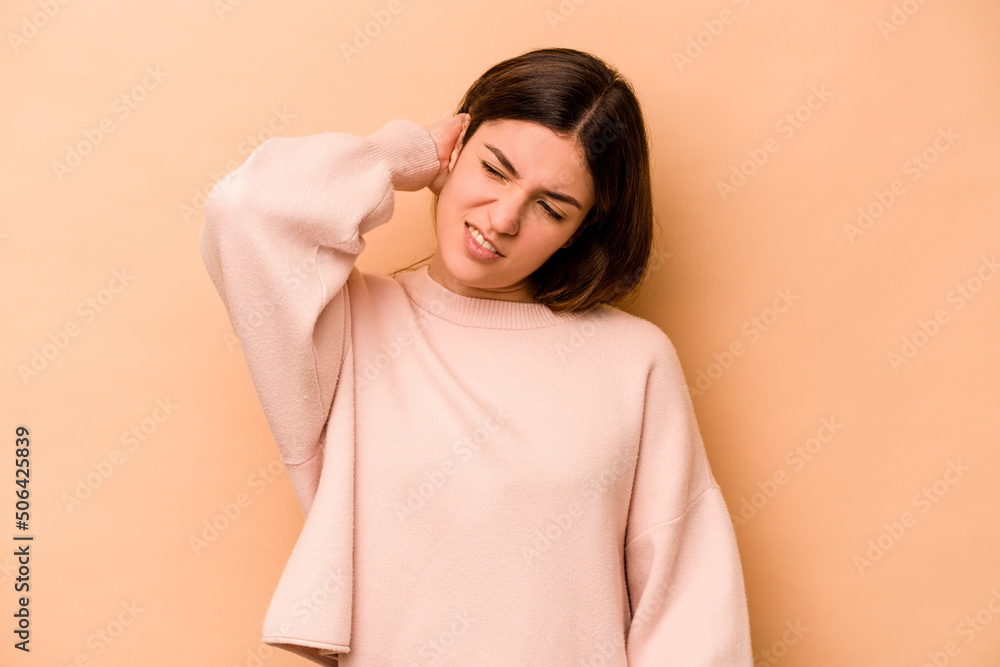 Young hispanic woman isolated on beige background tired and very sleepy keeping hand on head.