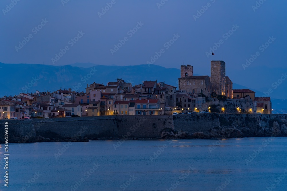 Landscape view on the old coastal village and fortification of Antibes on the french riviera in France during the blue hour