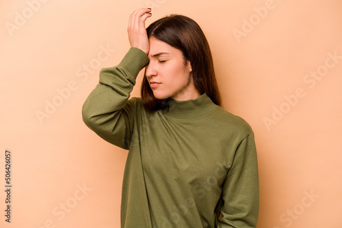 Young hispanic woman isolated on beige background forgetting something, slapping forehead with palm and closing eyes. © Asier