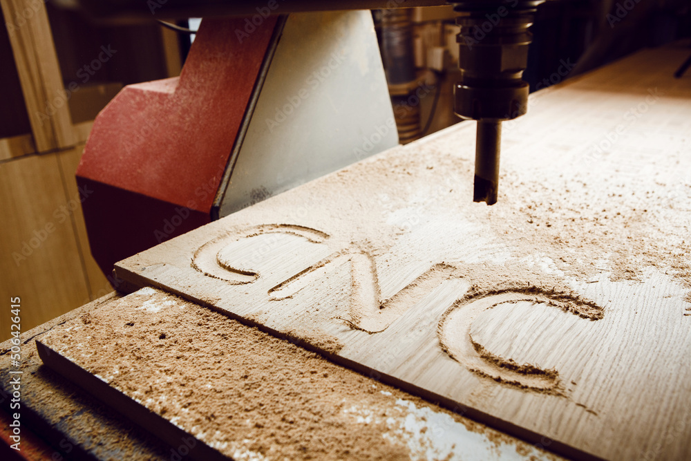 Cnc machine at carpentry workshop. Cutting wood with various router ...