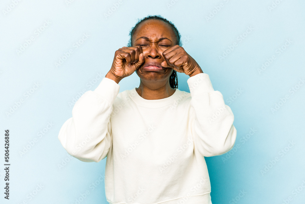 Young african american woman isolated on blue background whining and crying disconsolately. Young african american woman isolated on blue background whining and crying disconsolately.
