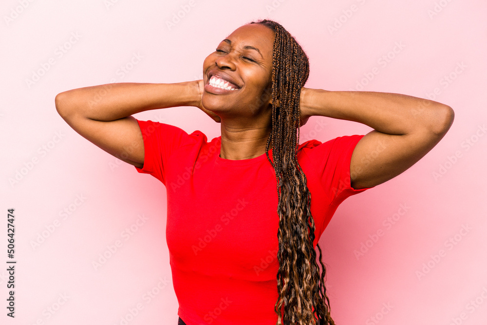 Young african american woman isolated on pink background feeling confident, with hands behind the head. Young african american woman isolated on pink background feeling confident, with hands behind the head.
