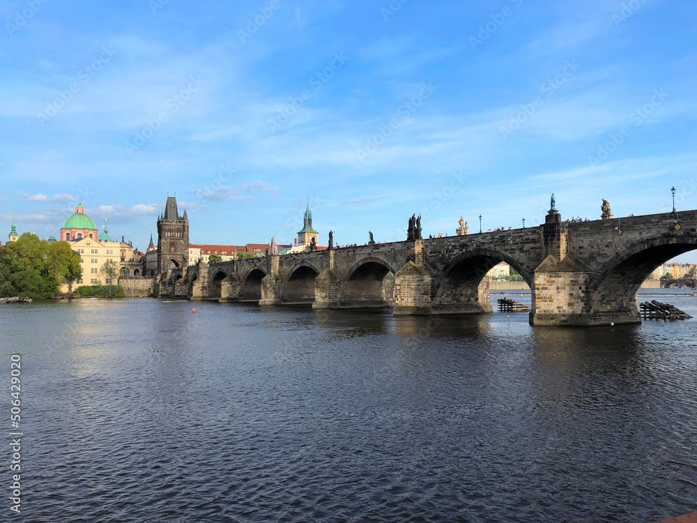 A medieval stone bridge spans the wide river