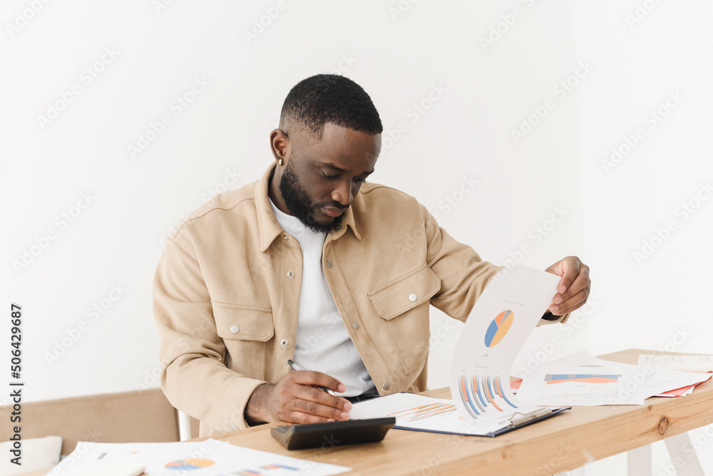 African American young man reads a letter from a bank about financial problems with credit debt. Black man finds out about budget issues, feels frustrated, worried about bad report or bad test results African American young man reads a letter from a bank about financial problems with credit debt. Black man finds out about budget issues, feels frustrated, worried about bad report or bad test results