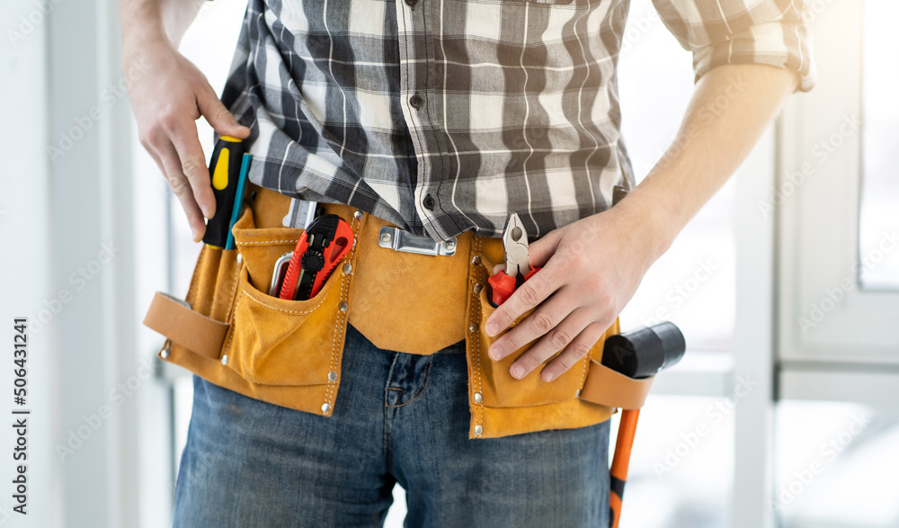 Fitter wearing belt with professional tools on hips Fitter wearing belt with professional tools on hips