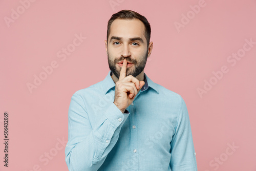 Fotografija Young secret caucasian man 20s wearing classic blue shirt say hush be quiet with finger on lips shhh gesture isolated on plain pastel light pink background studio portrait