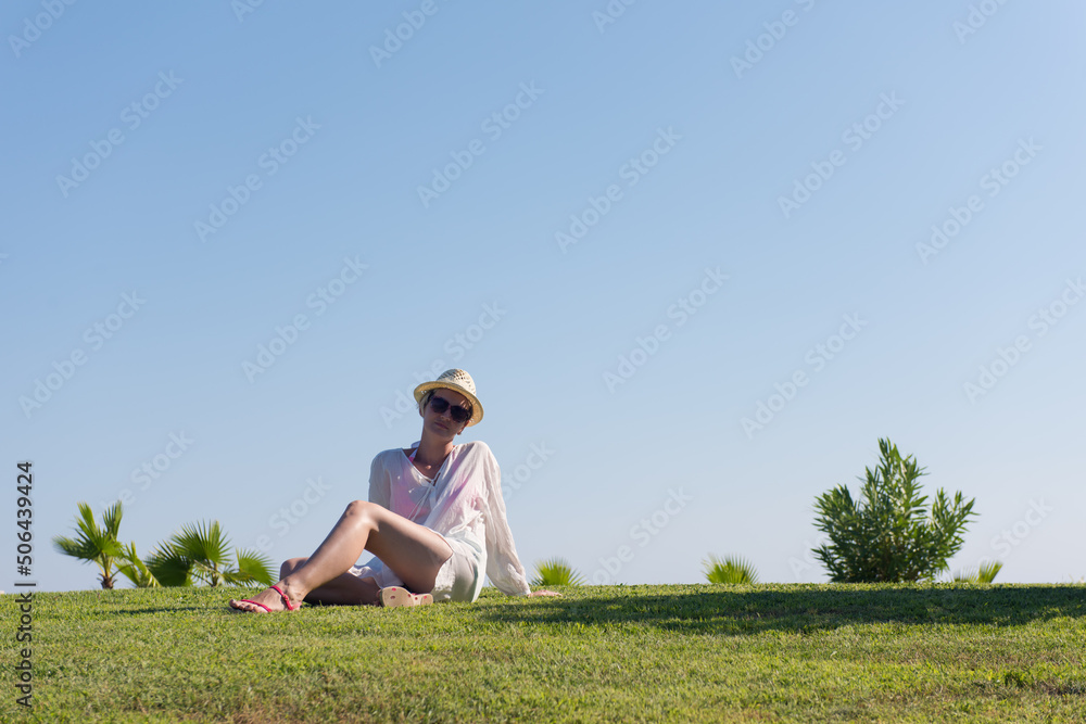 Woman lying and reading her favorite book on a meadow covered with fresh green grass on a sunny summer or spring day. Woman lying and reading her favorite book on a meadow covered with fresh green grass on a sunny summer or spring day.