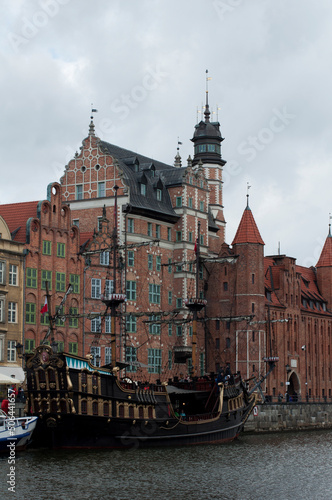 Pirate frigate on Motlawa River Embankment in Gdansk. View of the river with ships and the old town. Historical and tourist attractions in Poland