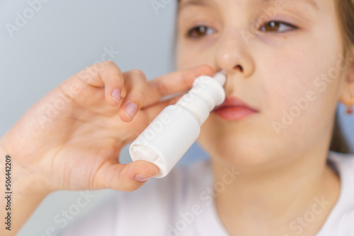 Little girl with runny nose does nasal spray irrigations to stop allergic rhinitis and sinusitis