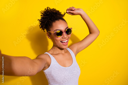 Fotografia Portrait of cheerful nice girl arm touch hair curl take selfie isolated on yello