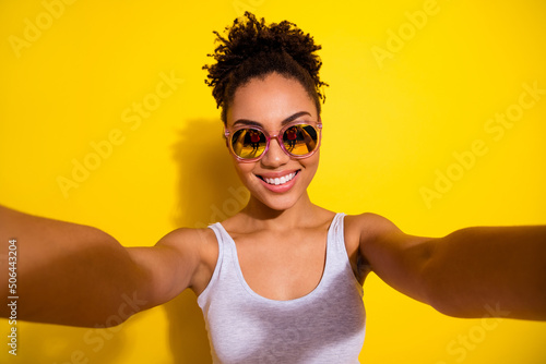 Portrait of funky positive girl take selfie recording video toothy smile isolated on yellow color background
