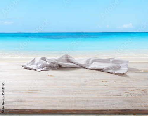 White napkin, table cloth on wooden deck mockup. Sea beach background