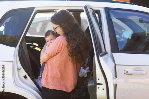 New mum putting baby in car to go out and about with newborn photo