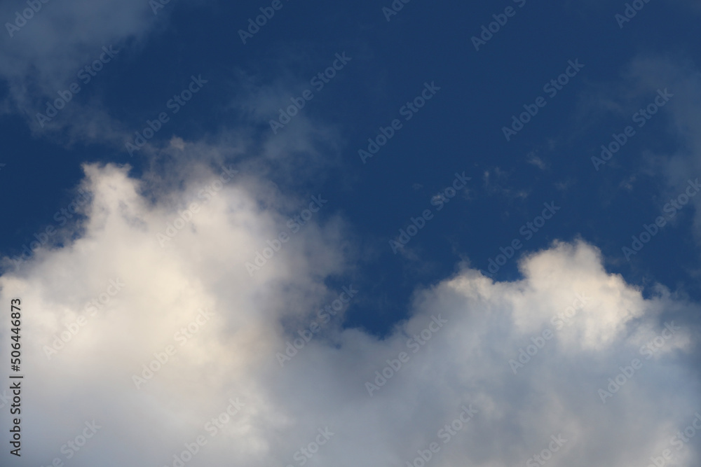 White clouds against a dark blue sky, atmosphere and meteorology. White clouds against a dark blue sky, atmosphere and meteorology.