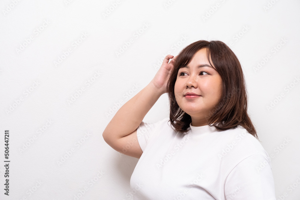 Young beautiful Asian oversize women smile with positive emotion, feeling happy and proud with her body size. Portrait shot on white background with copy space. Young beautiful Asian oversize women smile with positive emotion, feeling happy and proud with her body size. Portrait shot on white background with copy space.