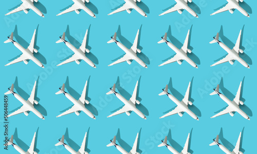 Creative composition made with passenger plane on blue background. Summer travel or vacation pattern.