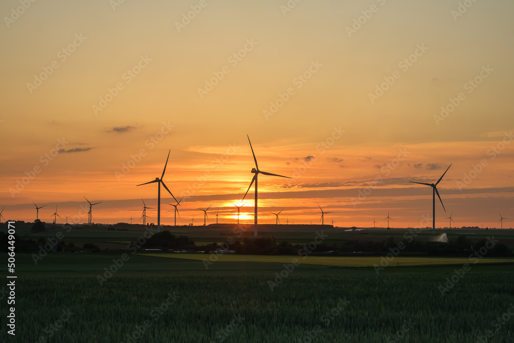 Obraz premium Wind turbines and an amazing golden sunset in Heron Belgium