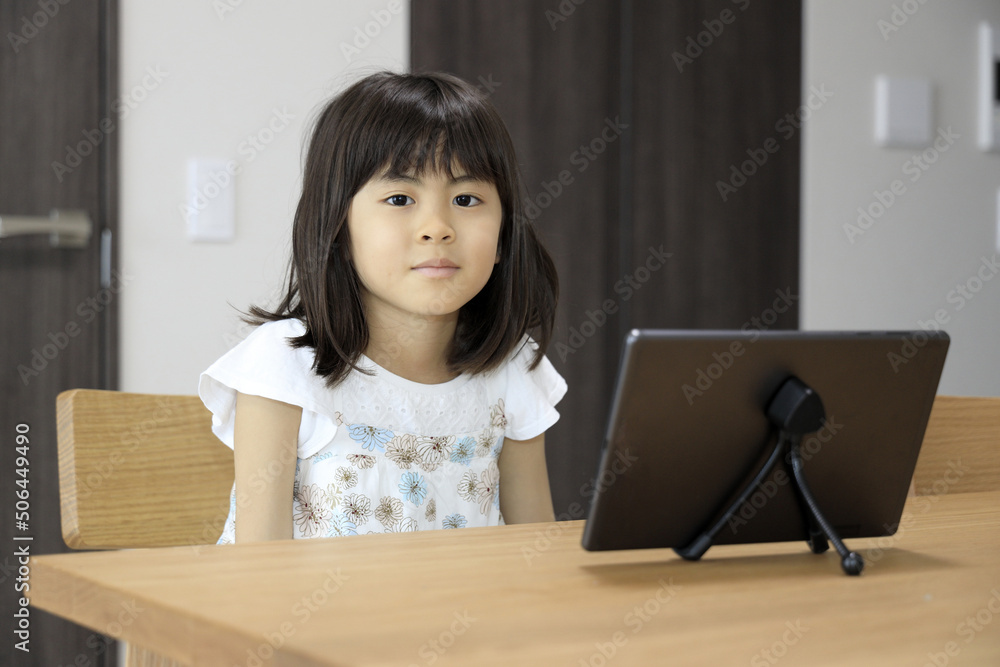タブレットで動画を見る女子小学生 (7歳)