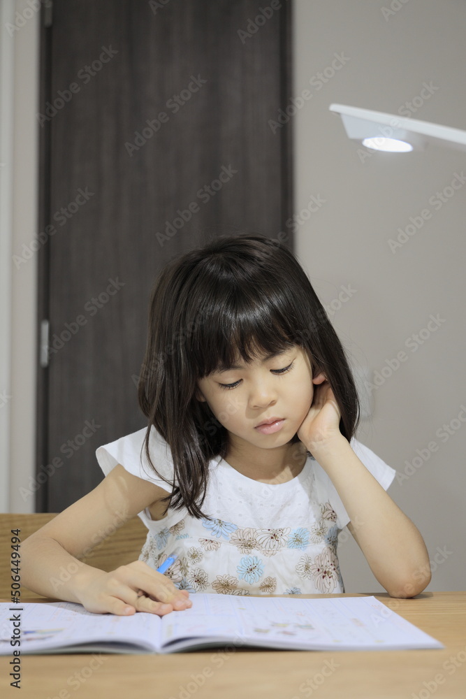 ダイニングで勉強をする女子小学生 (7歳)