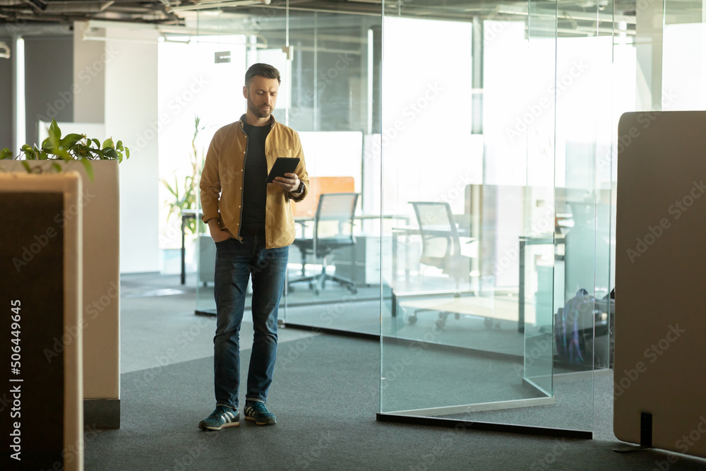 Cheerful Businessman Using Digital Tablet Computer Entering Modern Office Cheerful Businessman Using Digital Tablet Computer Entering Modern Office