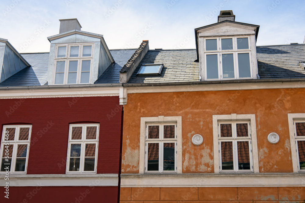  House facades in Copenhagen, Denmark. City street with old red and yellow houses. Real estate investment. Expensive housing in the center of the city.