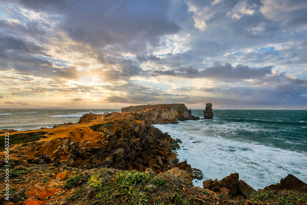 Beautiful scenic sunset over Atlantic ocean. Rocky cliff on Peniche in Portugal.