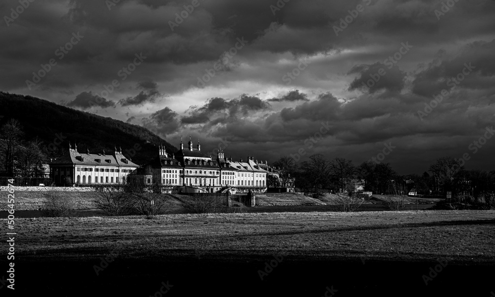 Repräsentatives Schloss mit dunklen Wolken in Schwarz und Weiß