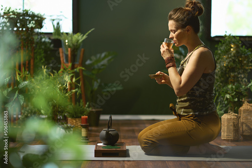 Принти на полотні stylish woman with tea in modern green house