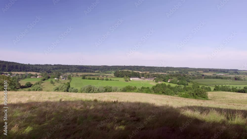 Aerial View: Drone establishing shot forward motion over the dutch valley landscape with hills and farmlands, meadows with natural fences wooded banks, rural roads with blue sky in South Limburg Vaals Aerial View: Drone establishing shot forward motion over the dutch valley landscape with hills and farmlands, meadows with natural fences wooded banks, rural roads with blue sky in South Limburg Vaals