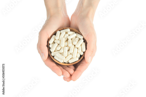 White capsules. Female hands holds white capsule collagen