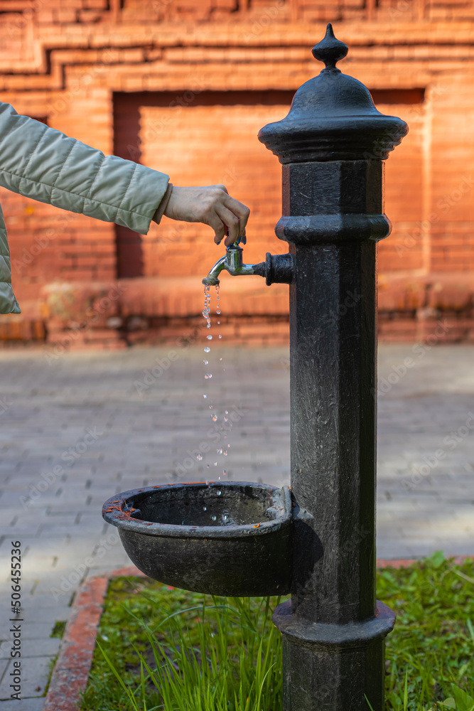 woman's hand opens the faucet of the water column on the street woman's hand opens the faucet of the water column on the street