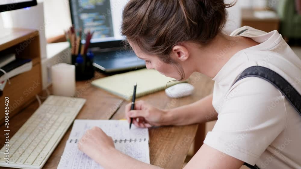 Focused and concentrated young woman takes notes fast, remote working at home office. Student makes abstract during distance online education, sitting at table close up view. Focused and concentrated young woman takes notes fast, remote working at home office. Student makes abstract during distance online education, sitting at table close up view.