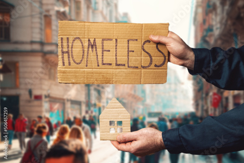 Foto A man hold a cardboard house and sign with the inscription HOMELESS