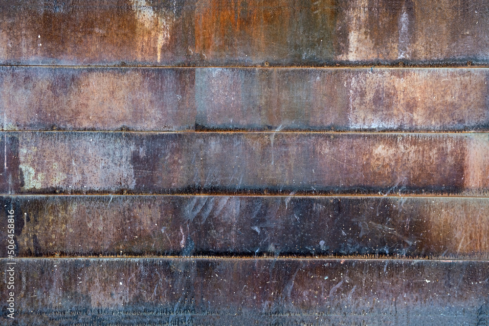 Rusted metal wall texture or old oxidized metal fence background with horizontal metal rusty tiles
