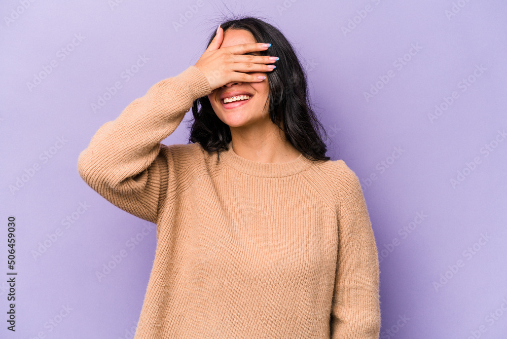Young hispanic woman isolated on purple background covers eyes with hands, smiles broadly waiting for a surprise. Young hispanic woman isolated on purple background covers eyes with hands, smiles broadly waiting for a surprise.