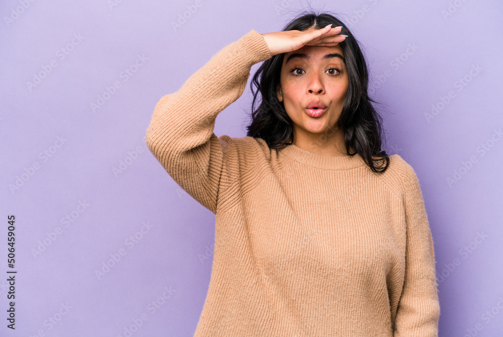 Young hispanic woman isolated on purple background looking far away keeping hand on forehead. Young hispanic woman isolated on purple background looking far away keeping hand on forehead.