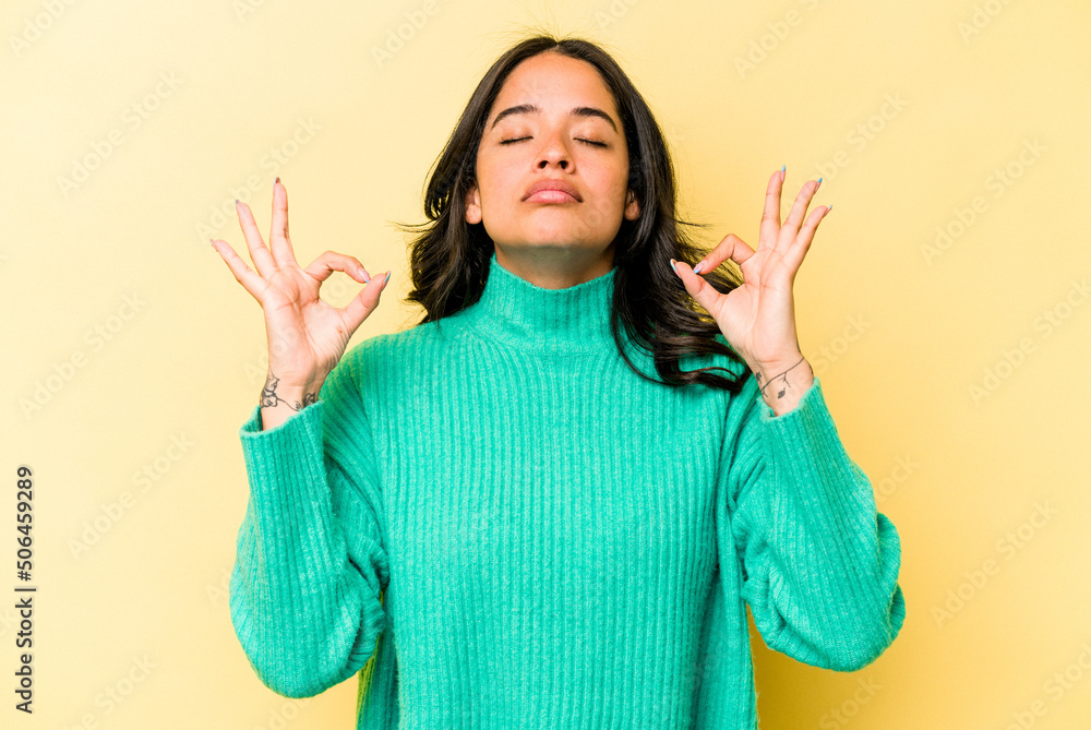 Young hispanic woman isolated on yellow background relaxes after hard working day, she is performing yoga. Young hispanic woman isolated on yellow background relaxes after hard working day, she is performing yoga.