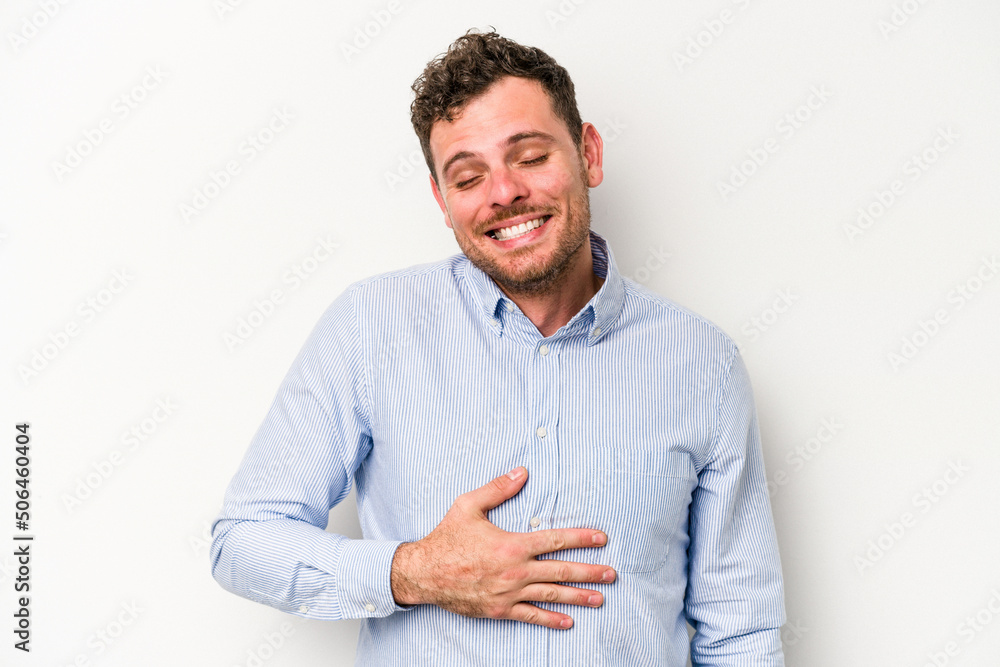 Young caucasian man isolated on white background touches tummy, smiles gently, eating and satisfaction concept. Young caucasian man isolated on white background touches tummy, smiles gently, eating and satisfaction concept.