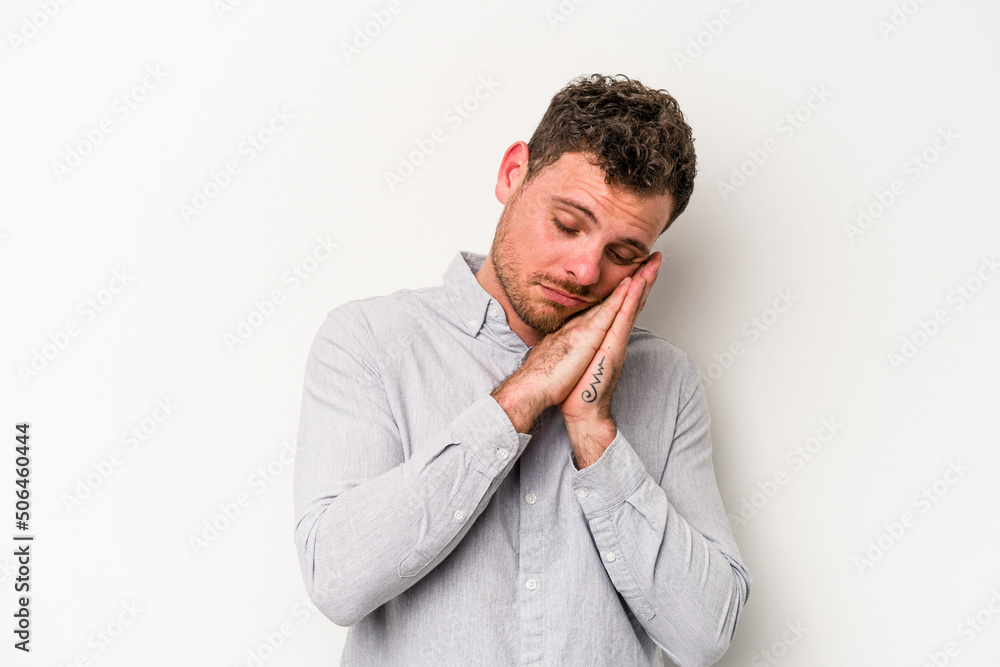 Young caucasian man isolated on white background yawning showing a tired gesture covering mouth with hand.